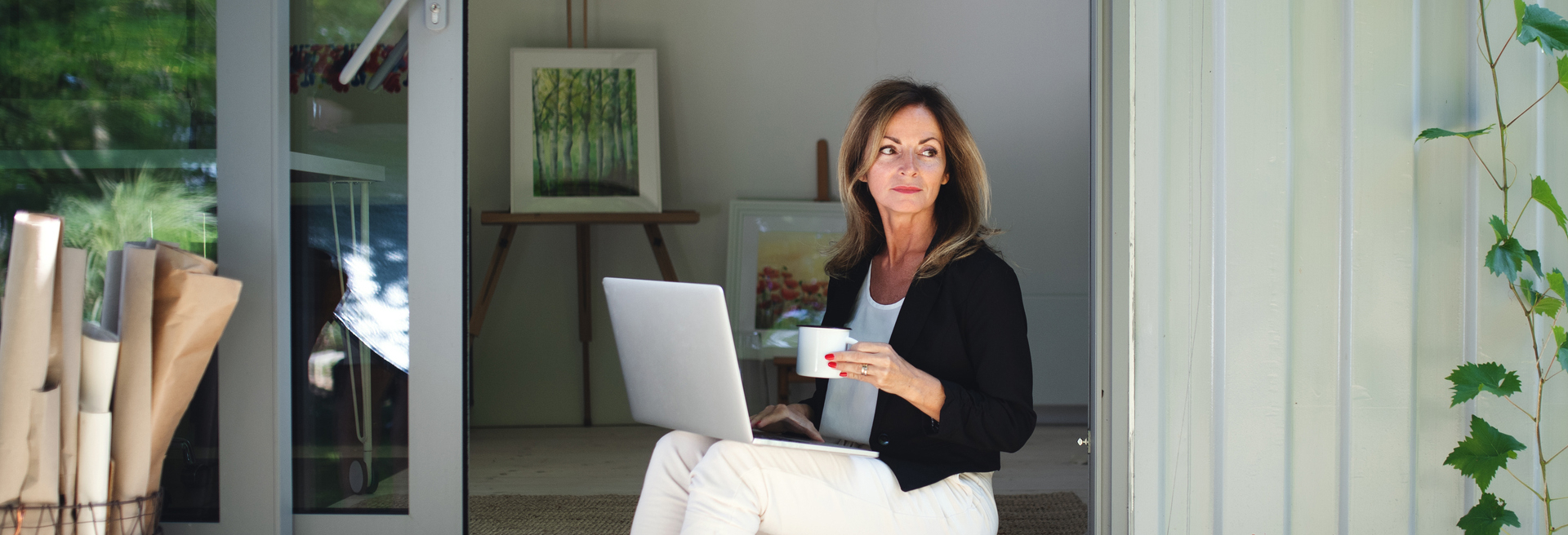 Woman working on her laptop in her garden office