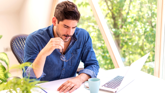 Man working at his laptop in his garden office