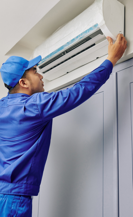 Man repairing a wall mounted air conditioning unit