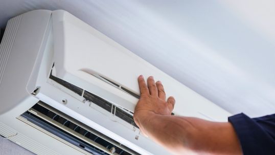 man servicing an air conditioner