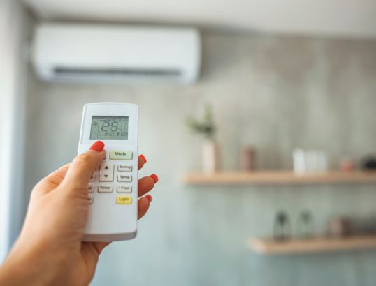 person using an air conditioning remote