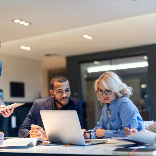 man and woman looking at laptop in office